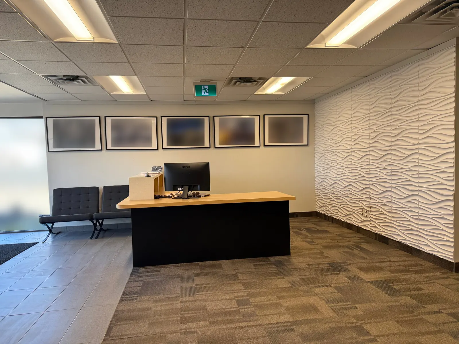 Office reception area with a wood-top desk, waiting chairs and carpet-tile floor after a Celestial office clean